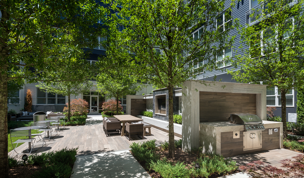 Cirro luxury apartments' outdoor patio in King of Prussia, PA, featuring a grill & dining tables.